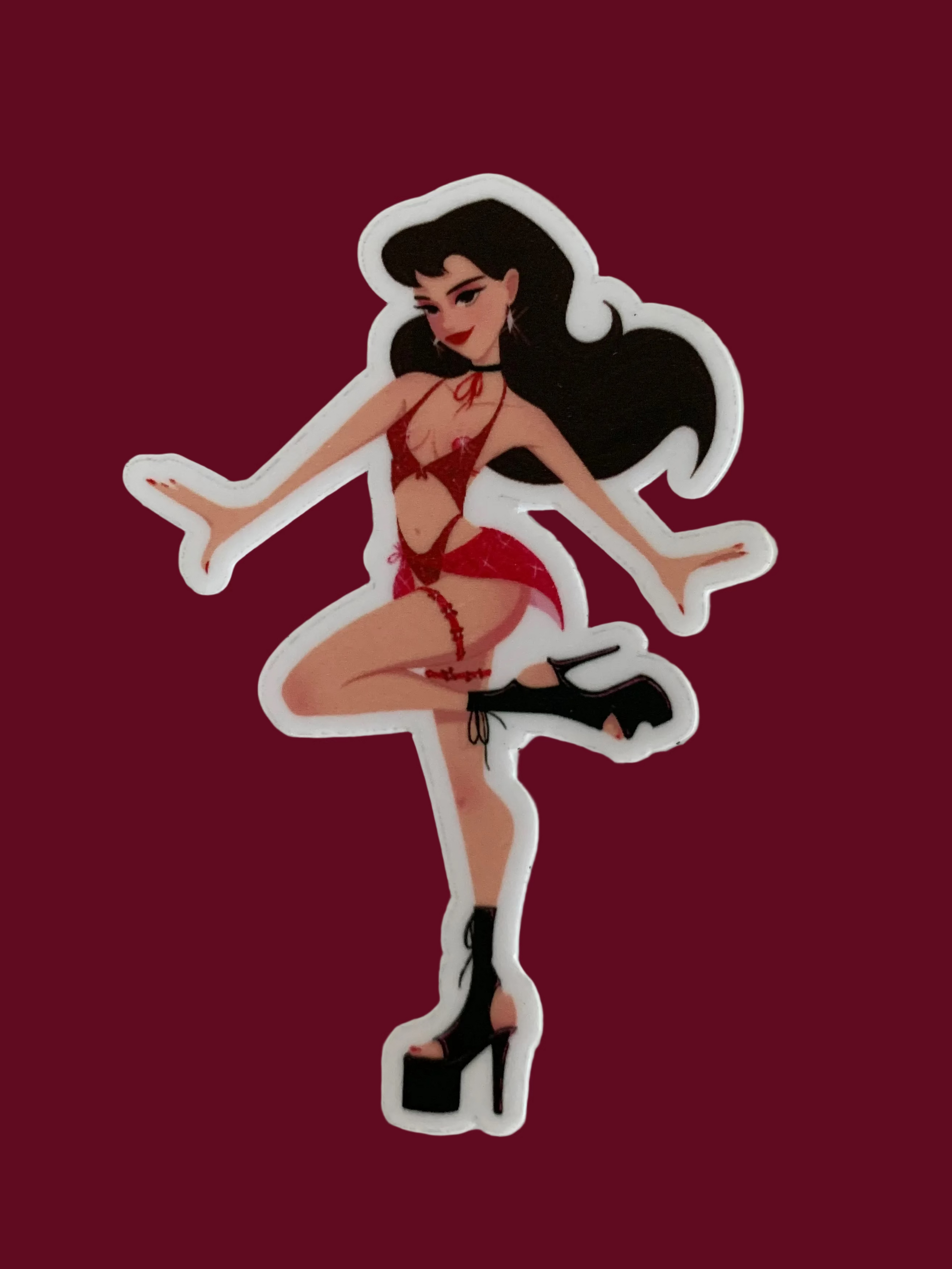 A die-cut vinyl sticker featuring an illustrated pin-up style woman with long black hair, a red bikini, and black high heels, shown on a plain off-white background.